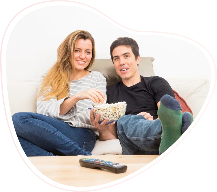 Pareja viendo televisión en casa